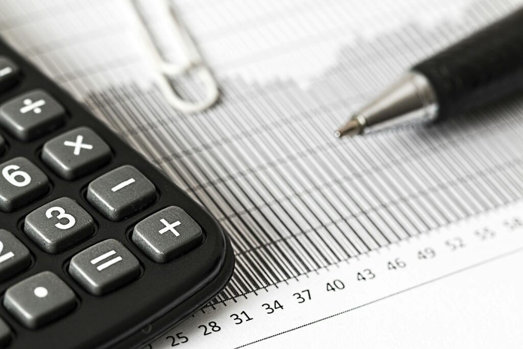 Calculator and pen on a printed financial spreadsheet